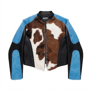 May include: A jacket featuring a brown and white cowhide print on the front panels, black leather side panels, and bright blue textured sleeves. The collar is black with a label reading CUSTOM THREAD PK, and the front has a central zipper closure.