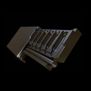 May include: A metallic industrial mold component featuring a series of seven elongated, oval-shaped recessed cavities arranged in a row. The structure includes a flat rectangular section and a cylindrical tube extending along the side of the base.