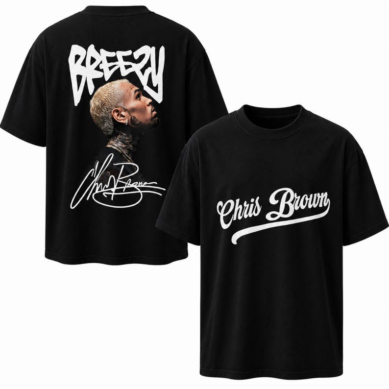 May include: A black short-sleeved t-shirt featuring a white graphic on the front that reads Chris Brown in cursive script. The back displays a photographic portrait of a person with blonde hair, the word BREEZY in white, and a white signature.