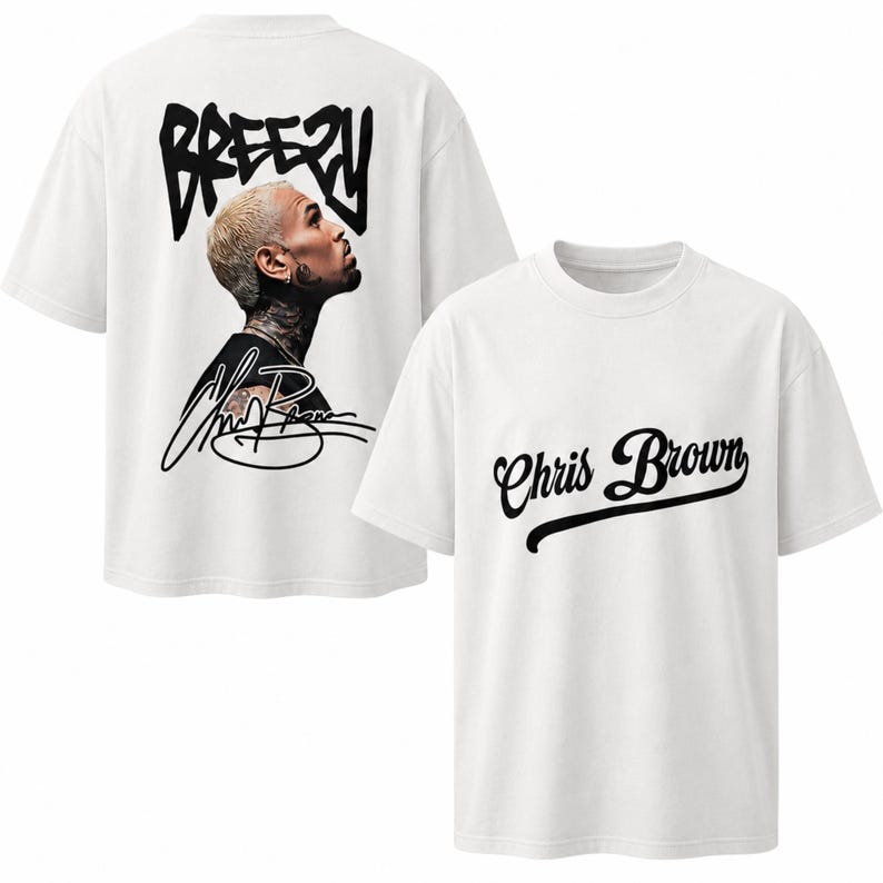 May include: A white short-sleeved t-shirt featuring a graphic on the back with the word BREEZY in black lettering above a portrait of Chris Brown and his signature. The front of the shirt displays the name Chris Brown in black cursive script.