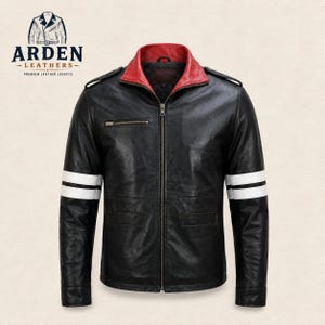 Könnte beinhalten: Eine schwarze Lederjacke mit rotem Innenkragen, durchgehendem Frontreißverschluss und zwei horizontalen weißen Streifen an jedem Ärmel. Die Jacke verfügt über Schulterklappen, eine kleine Brusttasche mit Reißverschluss und zwei Vordertaschen.
