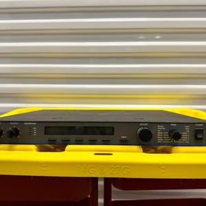 May include: A black Lexicon LXP-15 rack-mount audio processor featuring a front panel with two input and output knobs, a central digital display screen, a large adjustment dial, a page selection knob, and a power switch on the right side.