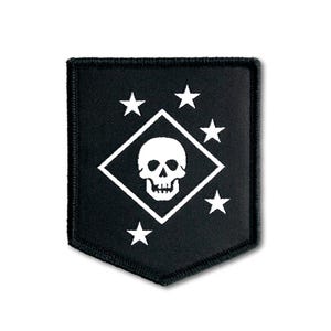 May include: A black shield-shaped patch featuring a white embroidered design. The center displays a white skull inside a diamond outline, surrounded by five white stars arranged in a pattern around the diamond on the black fabric background.
