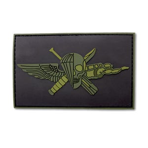 May include: A rectangular morale patch featuring a dark gray background with an olive green design. The graphic depicts a skull split with a parachute canopy, a wing, and a knife, all layered over crossed tactical equipment in olive green.
