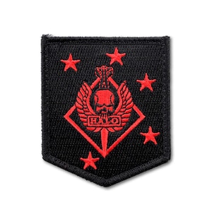 May include: A black embroidered patch with a red design featuring a central skull with wings inside a diamond shape, the word HALO in a rectangular box, and four five-pointed stars surrounding the emblem on a black fabric background.