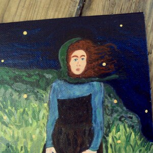 Op de afbeelding: Een schilderij van een vrouw met lang rood haar die een blauwe en groene jurk draagt ​​en in een veld met groen gras staat onder een donkerblauwe lucht met gele sterren.