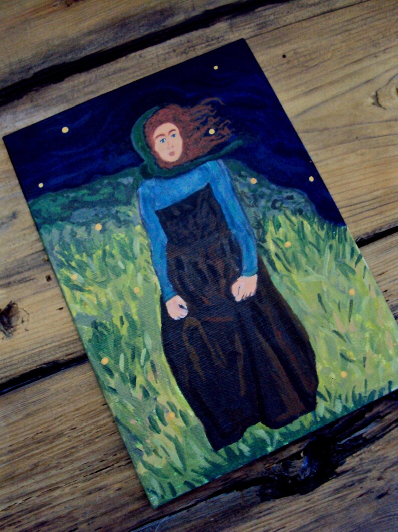 Op de afbeelding: Een schilderij van een vrouw met lang rood haar die een blauw shirt en een lange zwarte rok draagt. De vrouw staat in een veld met groen gras en gele bloemen. De achtergrond is een donkerblauwe lucht met witte sterren.