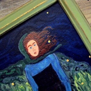 Op de afbeelding: Een schilderij van een vrouw met lang rood haar die een groene kapmantel en een blauwe jurk draagt. De achtergrond is donkerblauw met gele sterren en groen gebladerte.