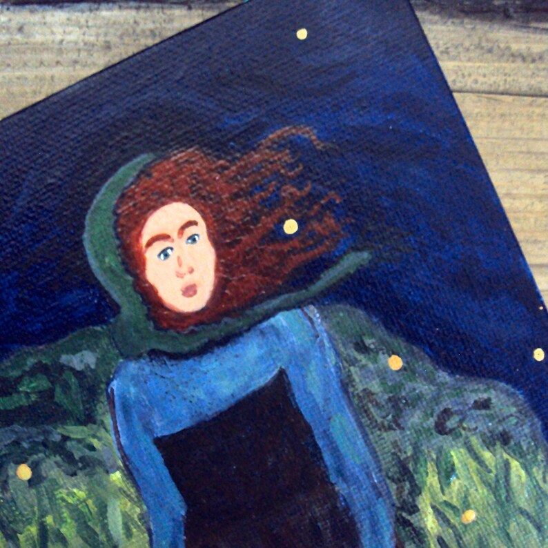 Op de afbeelding: Een schilderij van een vrouw met lang rood haar die een blauwe en groene kapmantel draagt. De achtergrond is donkerblauw met gouden sterren.
