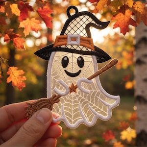 May include: A white embroidered ghost patch featuring a black witch hat with an orange band, a brown broomstick, and a small orange star on its chest. The ghost has a web-like pattern throughout its body, black eyes, and a smiling mouth.
