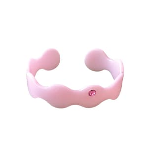 May include: A light pink, open cuff bracelet with a wavy design. The bracelet features a small, round, pink gemstone set in the center. The bracelet is made of a smooth, glossy material.
