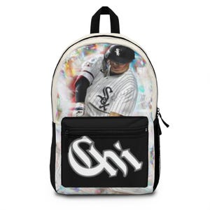 May include: A black and white backpack featuring a graphic of a baseball player in a pinstriped jersey with a team logo. The front pocket displays the text Chi in a large, stylized white font with a grey outline against a solid black background.