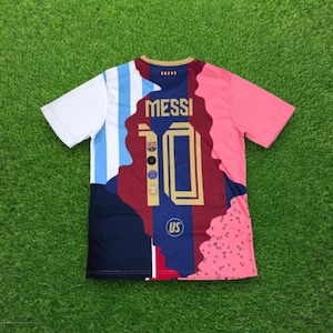 May include: A short-sleeve jersey featuring a multi-colored design with white and light blue stripes on the left, a central maroon panel with the name MESSI and the number 10 in gold, and a pink side panel with a black dotted pattern on the right.