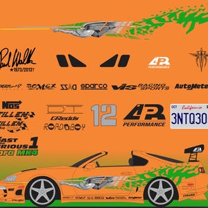 May include: A decal sheet featuring an orange Toyota Supra MK4 with green graphics, the text Fast and Furious 1, a California 3NTQ305 license plate, Paul Walker 1973/2013 signature, and various automotive brand logos including Sparco, GReddy, and NOS.