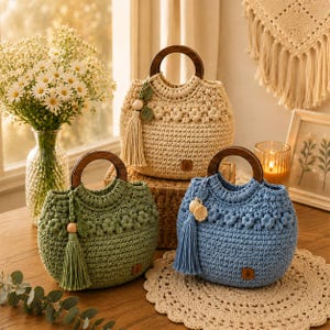 May include: Three round crochet handbags in cream, sage green, and light blue. Each bag features a dark brown circular wooden handle, a textured floral pattern around the top, and a matching tassel with a wooden bead attached to the side.
