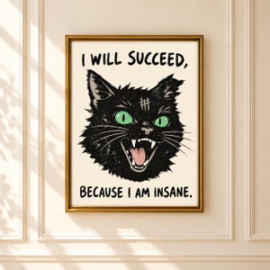 Puede incluir: Una lámina enmarcada con la ilustración de un gato negro de ojos verde brillante y boca abierta mostrando los dientes. El texto superior dice I WILL SUCCEED, y el inferior dice BECAUSE I AM INSANE. El gato tiene un símbolo de almohadilla en la frente.