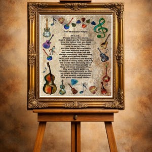 May include: A framed print on an easel features "The Musicians Prayer" with musical instrument illustrations. The gold frame surrounds the text and colorful drawings of guitars, violins, and musical notes. The easel is made of wood.