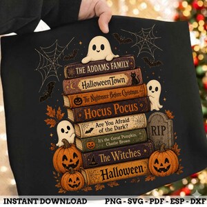 Peut inclure: Un t-shirt noir avec une pile de livres portant les titres The Addams Family, Halloween Town, The Nightmare Before Christmas, Hocus Pocus, Are You Afraid of the Dark?, The Great Pumpkin, Charlie Brown, The Witches et Halloween.