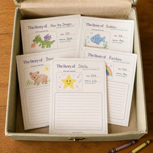Puede incluir: Un conjunto de plantillas de papel blanco para escribir historias con texto y l&iacute;neas azules, que incluyen ilustraciones a mano de un drag&oacute;n verde, un pez azul, un oso marr&oacute;n, un arco&iacute;ris y una estrella amarilla, dentro de una caja de tela beige.