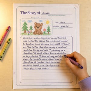 A printed keepsake story page reading "The Story of Bramble" with a crayon drawing of a sleepy bear in the corner and a short handwritten bedtime story filling the ruled lines, a child's hand coloring nearby with crayons on a wooden table, from the AiWhizzkids Keepsake Story Book Pack.