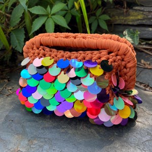 Clutch aus gehäkelten Pailletten in Rost- und Regenbogenfarben