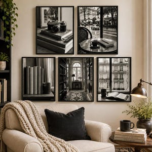 Puede incluir: Una pared de galería con cinco láminas en blanco y negro que muestran una cámara vintage sobre libros, una mesa de café parisina, una hilera de libros, un pasillo de biblioteca y una ventana urbana, sobre un sillón beige con manta.