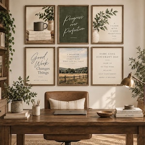 May include: A gallery wall of six framed prints featuring motivational text and landscape imagery above a wooden desk. The prints include phrases like Progress over Perfection, Good Work Changes Things, and Same Goal Different Day, displayed in dark wood frames.