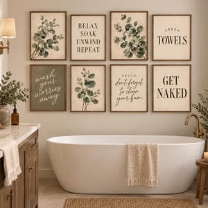 May include: A set of eight framed wall art prints displayed in a bathroom. The prints feature botanical eucalyptus illustrations and text including "RELAX SOAK UNWIND REPEAT", "FRESH TOWELS", "wash your worries away", "don't forget to clean your bum", and "GET NAKED".