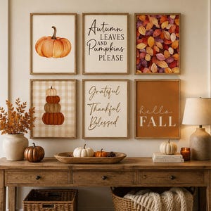 Könnte beinhalten: Eine Galeriewand mit sechs gerahmten Drucken zu herbstlichen Themen, darunter Kürbisse, Herbstblätter und die Texte Autumn Leaves and Pumpkins Please, Grateful Thankful Blessed sowie hello FALL, über einem Konsolentisch aus Holz.