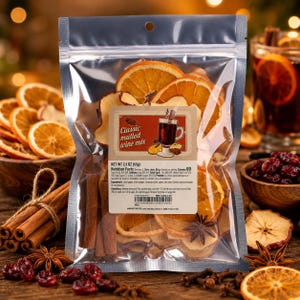 May include: A clear plastic pouch containing a classic mulled wine mix with dried orange slices, apple slices, cinnamon sticks, and star anise. The label features the text Classic mulled wine mix, net weight 65g, and nutrition facts.