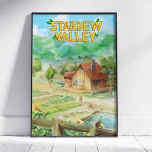 May include: A framed wall art print featuring a watercolor-style landscape of a wooden farmhouse with a red roof, surrounded by green fields, a small pond, and sunflowers. The text "STARDEW VALLEY" is displayed in large, yellow, wooden-style letters.