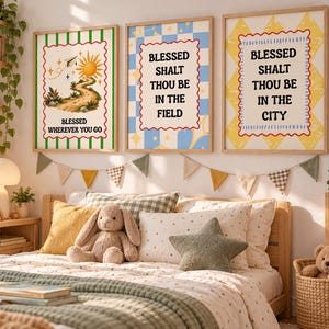 Puede incluir: Tres láminas decorativas enmarcadas en madera clara. La de la izquierda muestra un sol, un camino y el texto "BLESSED WHEREVER YOU GO". La central tiene un fondo de cuadros azules y el texto "BLESSED SHALT THOU BE IN THE FIELD". La de la derecha tiene un patrón amarillo y el texto "BLESSED SHALT THOU BE IN THE CITY".