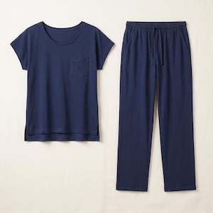 Könnte beinhalten: Ein marineblaues Pyjama-Set bestehend aus einem kurzärmeligen T-Shirt mit einer Brusttasche und Seitenschlitzen am Saum sowie einer passenden langen Hose mit elastischem Bund und einem Kordelzug zum Binden.