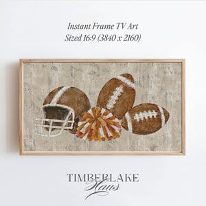 Op de afbeelding: Een digitaal kunstwerk voor een frame-tv met een bruine footballhelm, twee bruine footballs en een veelkleurige pompon op een getextureerde beige achtergrond. De tekst luidt: Instant Frame TV Art Sized 16:9 (3840 x 2160) en TIMBERLAKE HAUS.