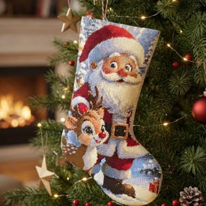 Peut inclure: Une chaussette de Noël ornée d'une broderie diamant représentant le Père Noël en costume rouge et un renne aux grands yeux. La chaussette présente un revers blanc, une boucle de suspension et une surface texturée faite de petites perles colorées.