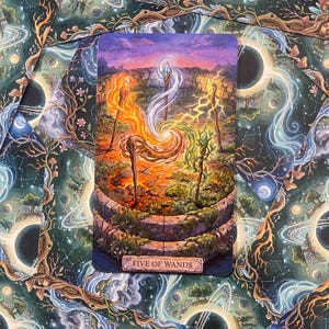 Może przedstawiać: Prostokątna karta tarota z napisem Five of Wands, przedstawiająca żywą ilustrację pięciu drewnianych kosturów stojących w kręgu na spękanej ziemi. Każdy kostur emituje inną energię żywiołów, w tym ogień, lód, błyskawice, ziemię i wiatr.
