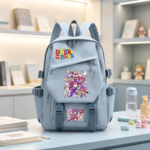 May include: A light blue backpack featuring the text "DIGITAL CIRCUS" in colorful letters at the top. The front pocket displays a vibrant graphic of various cartoon characters, with a smaller grid of character portraits located below it.