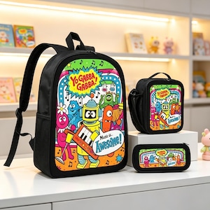 May include: A black backpack, lunch bag, and pencil case set featuring a colorful Yo Gabba Gabba graphic print. The design includes characters, musical notes, and the text Yo Gabba Gabba! and Music is Awesome! on a vibrant, multi-colored background.