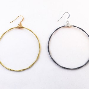 May include: Two pairs of hoop earrings made from twisted wire. One pair is gold and the other is silver.