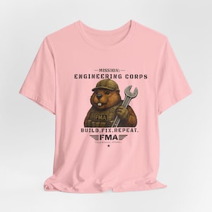 Könnte beinhalten: Ein hellrosa T-Shirt mit einer Grafik eines braunen Bibers, der eine taktische Weste und eine Kappe trägt und einen silbernen Schraubenschlüssel hält. Der Text lautet MISSION: ENGINEERING CORPS, FMA, BUILD.FIX.REPEAT. und FIELD MANUAL APPAREL.