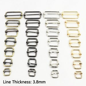 May include: A collection of rectangular metal sliders arranged in four vertical columns by colour: antique brass, gunmetal, silver, and gold. Each column features sliders of varying sizes, from largest at the top to smallest at the bottom. Line Thickness: 3.8mm.