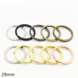 Può includere: Dieci anelli portachiavi circolari in metallo disposti su due file, ciascuno con un diametro di 29mm. La collezione include varie finiture metalliche come argento, nero, canna di fucile, bronzo antico, oro e oro rosa.