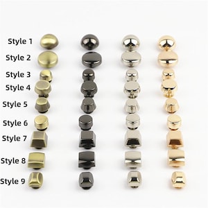 Può includere: Una collezione di bottoni in metallo disposti in nove file etichettate da Style 1 a Style 9. I bottoni sono presentati in quattro colonne verticali con finiture in ottone, canna di fucile, argento e oro, in varie forme rotonde e quadrate.