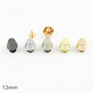 Può includere: Un set di cinque rivetti in metallo da 12 mm con una forma conica testurizzata. I rivetti sono presentati in varie finiture metalliche tra cui nero, argento e oro. Un rivetto è mostrato capovolto per rivelare il perno filettato e la base.