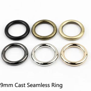 May include: Six circular metal rings arranged in two rows of three, each measuring 19mm. The top row features matte black, antique bronze, and brushed gold finishes. The bottom row includes gunmetal, polished silver, and bright gold finishes.