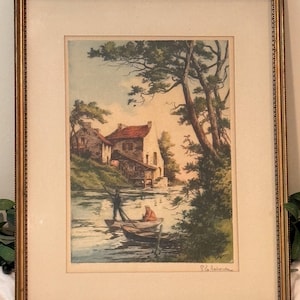 May include: A framed print featuring a landscape scene with stone buildings, tall pine trees, and two small boats on a river. One person stands in a boat using a pole, while another sits nearby. The artwork is signed P. Laborde in the bottom corner.