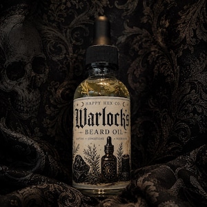 May include: A clear glass dropper bottle of Happy Hex Co. Warlock's Beard Oil. The label features black ink illustrations of a crystal, a bottle, and a candle, with the text: Happy Hex Co. Warlock's Beard Oil, Softens, Conditions, Nourishes.