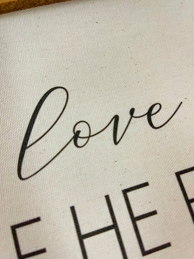 May include: Close-up of a white canvas sign with black text that reads "love together".
