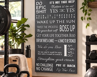 May include: A rectangular wall art piece with a dark gray background and white text featuring various motivational quotes including "Do Epic Shit," "Boss Up," and "No Challenge No Change." The sign is displayed on a wall in a gym setting.