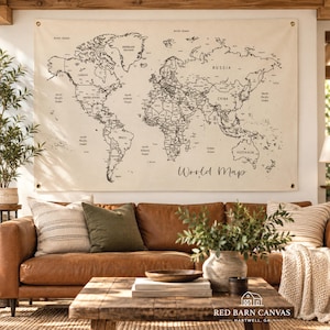 May include: A large, rectangular, off-white canvas wall hanging featuring a black-ink world map with clearly labeled continents, countries, and oceans. The text 'World Map' is printed in a cursive script in the lower right corner.